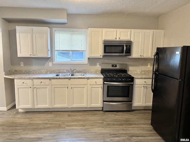 616 1st Ave, Silvis, IL 61282 - kitchen with appliances with stainless steel finishes, white cabinets, light countertops, and light wood-type flooring
