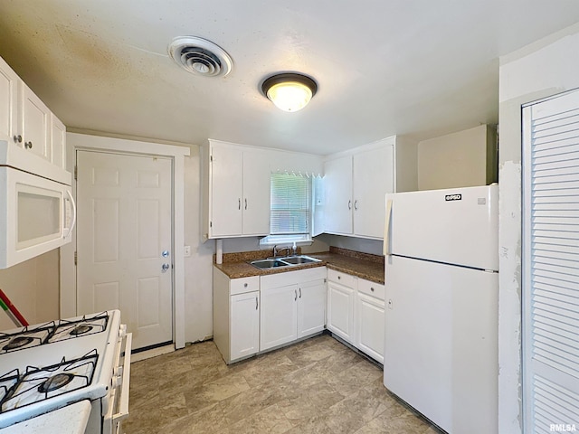 3327 2nd St, East Moline, IL 61244 - kitchen featuring white appliances, dark countertops, and white cabinetry