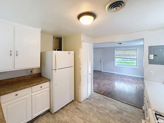 3327 2nd St, East Moline, IL 61244 - kitchen featuring freestanding refrigerator, white cabinetry, dark countertops, open floor plan, and electric panel
