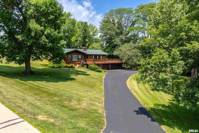 28002 230th St, Le Claire, IA 52753 - view of front of house featuring driveway, a deck, a front lawn, and a chimney