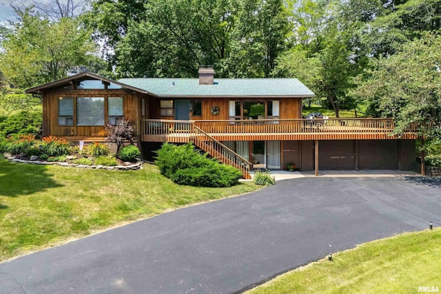 28002 230th St, Le Claire, IA 52753 - view of front of property featuring driveway, a chimney, a front yard, a deck, and stairs