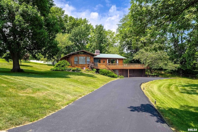 28002 230th St, Le Claire, IA 52753 - view of front of house featuring a deck, driveway, a front lawn, and a chimney