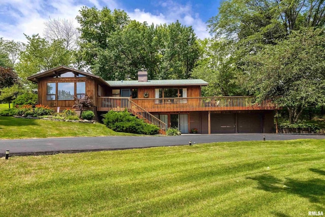 28002 230th St, Le Claire, IA 52753 - rear view of house with driveway, a chimney, a lawn, a wooden deck, and stairway
