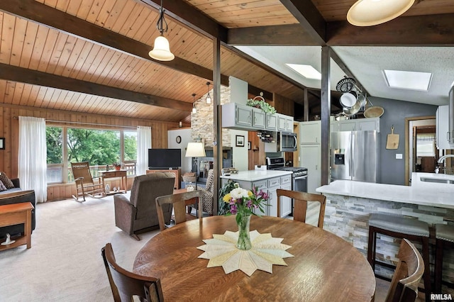 28002 230th St, Le Claire, IA 52753 - dining area with wood ceiling, light carpet, a skylight, and wood walls