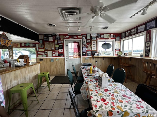 1204 N Cody Rd, Le Claire, IA 52753 - dining space with healthy amount of natural light, light tile patterned flooring, ceiling fan, wood walls, and rail lighting