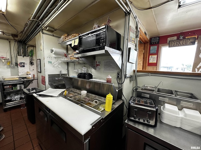 1204 N Cody Rd, Le Claire, IA 52753 - kitchen with dark tile patterned flooring and black microwave