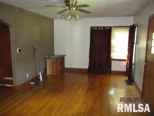 507 Waverly Rd, Davenport, IA 52804 - unfurnished room featuring a ceiling fan, arched walkways, and wood finished floors