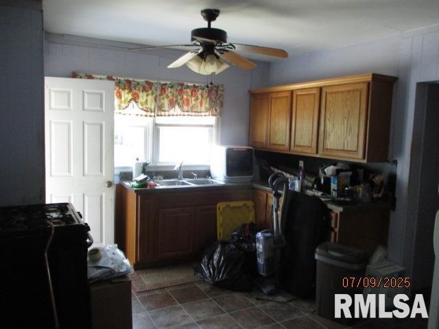 507 Waverly Rd, Davenport, IA 52804 - kitchen with ceiling fan, brown cabinetry, and dark countertops