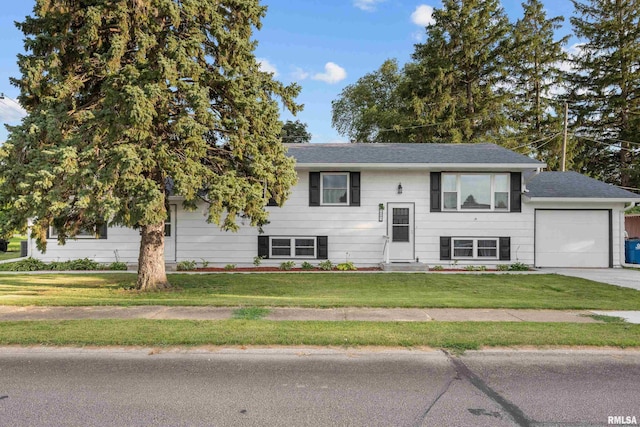 101 W Sheridan Dr, Eldridge, IA 52748 - bi-level home featuring a garage, a front yard, driveway, and a shingled roof
