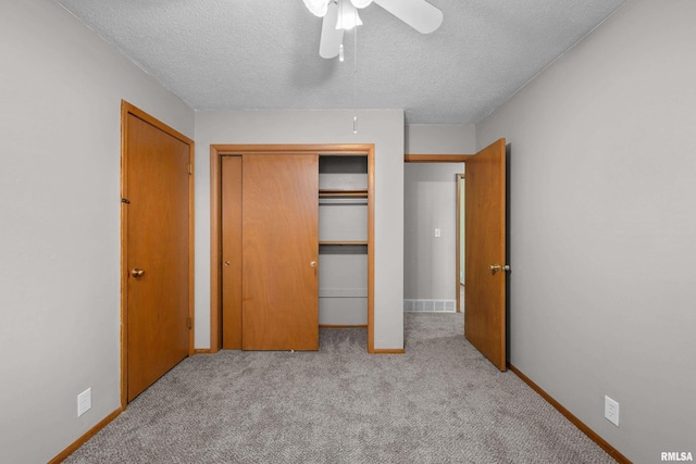 101 W Sheridan Dr, Eldridge, IA 52748 - unfurnished bedroom featuring carpet flooring, a textured ceiling, a closet, and ceiling fan