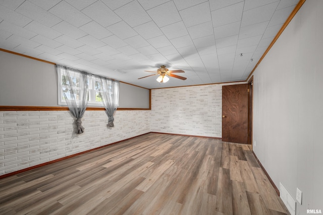101 W Sheridan Dr, Eldridge, IA 52748 - unfurnished room with a ceiling fan, wood finished floors, ornamental molding, and brick wall