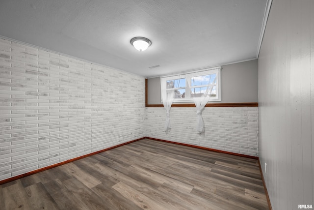 101 W Sheridan Dr, Eldridge, IA 52748 - unfurnished room with wood finished floors, a textured ceiling, and ornamental molding