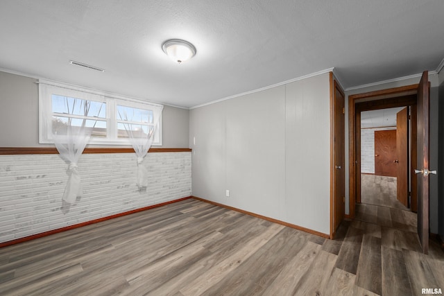 101 W Sheridan Dr, Eldridge, IA 52748 - empty room featuring wood finished floors, ornamental molding, and a textured ceiling