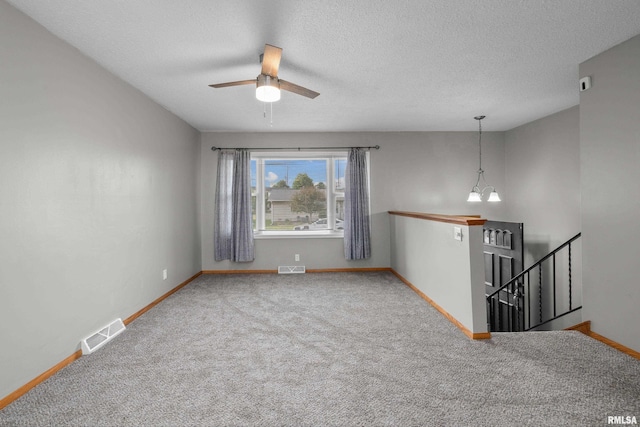 101 W Sheridan Dr, Eldridge, IA 52748 - empty room with carpet floors, a ceiling fan, a chandelier, and a textured ceiling