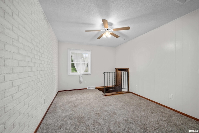 101 W Sheridan Dr, Eldridge, IA 52748 - carpeted empty room with a ceiling fan, a textured ceiling, and brick wall