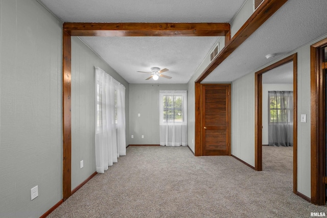 101 W Sheridan Dr, Eldridge, IA 52748 - spare room with carpet, a ceiling fan, beam ceiling, and a textured ceiling