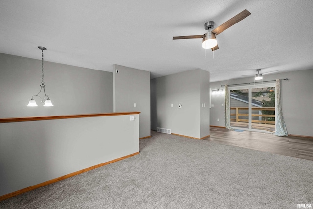 101 W Sheridan Dr, Eldridge, IA 52748 - unfurnished room featuring a ceiling fan, carpet, a chandelier, and a textured ceiling