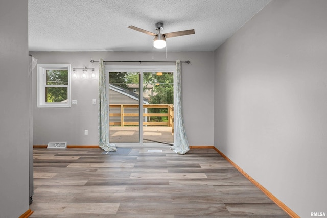 101 W Sheridan Dr, Eldridge, IA 52748 - spare room featuring a ceiling fan, plenty of natural light, a textured ceiling, and wood finished floors