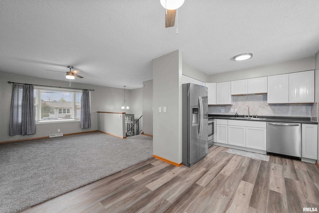 101 W Sheridan Dr, Eldridge, IA 52748 - kitchen with stainless steel appliances, ceiling fan, light wood-type flooring, dark countertops, and open floor plan