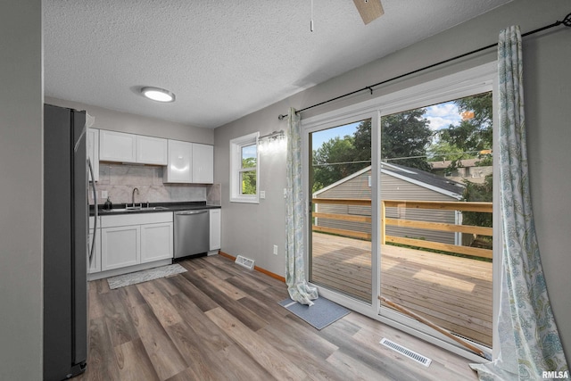 101 W Sheridan Dr, Eldridge, IA 52748 - kitchen featuring stainless steel appliances, white cabinets, dark wood-style flooring, and a textured ceiling