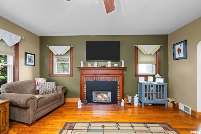 3110 Jefferson Ave, Davenport, IA 52803 - living area featuring ceiling fan, plenty of natural light, wood finished floors, and a brick fireplace