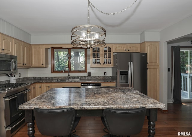 4512 11th Ave Unit C, Moline, IL 61265 - kitchen with stainless steel appliances, light brown cabinets, a chandelier, a breakfast bar, and glass insert cabinets