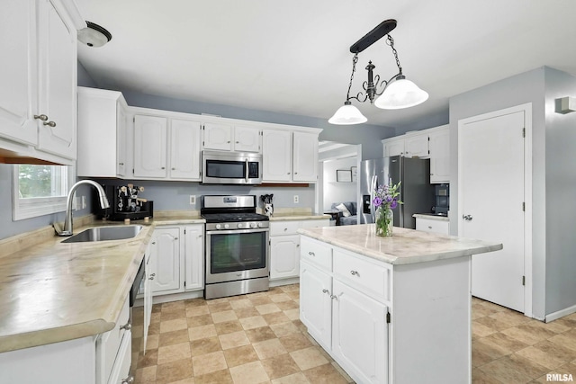 732 W 59th St, Davenport, IA 52806 - kitchen with stainless steel appliances, white cabinets, light countertops, a kitchen island, and pendant lighting