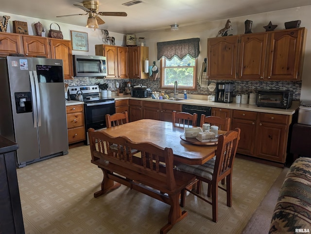 340 Dameron Ln, Vienna, IL 62995 - kitchen featuring appliances with stainless steel finishes, a ceiling fan, backsplash, light flooring, and light countertops