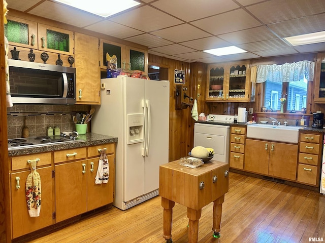 1723 Pershing Blvd, Clinton, IA 52732 - kitchen with stainless steel microwave, white refrigerator with ice dispenser, washer / dryer, a paneled ceiling, and light wood-style floors