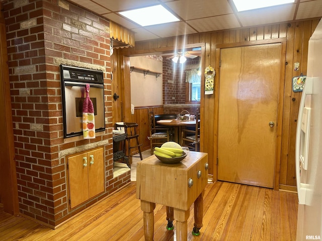 1723 Pershing Blvd, Clinton, IA 52732 - kitchen with stainless steel oven, light wood finished floors, wood walls, and ceiling fan