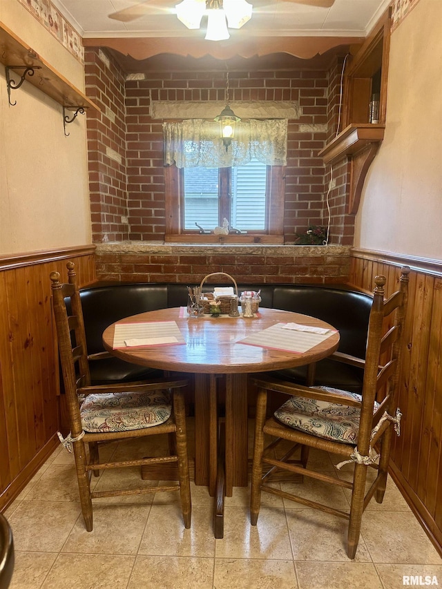 1723 Pershing Blvd, Clinton, IA 52732 - dining room with a wainscoted wall, wooden walls, and a ceiling fan