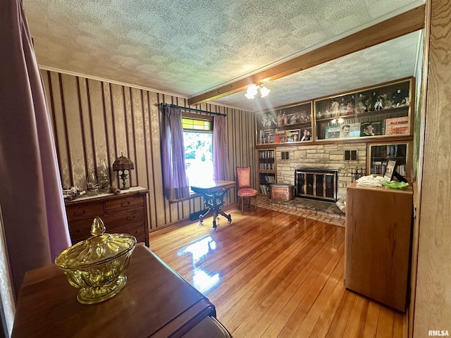 1723 Pershing Blvd, Clinton, IA 52732 - living room with a textured ceiling, hardwood / wood-style floors, a stone fireplace, and beamed ceiling