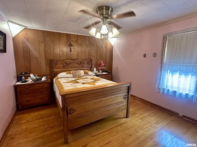 1723 Pershing Blvd, Clinton, IA 52732 - bedroom with light wood finished floors, ornamental molding, wooden walls, and ceiling fan