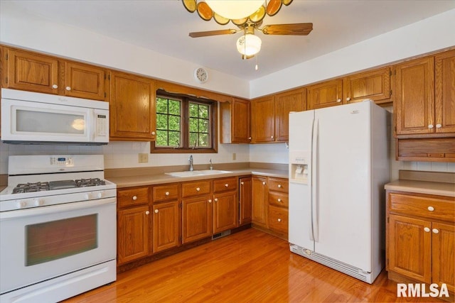 17223 N Cedar Rd, East Moline, IL 61244 - kitchen with white appliances, brown cabinets, light countertops, and light wood-type flooring