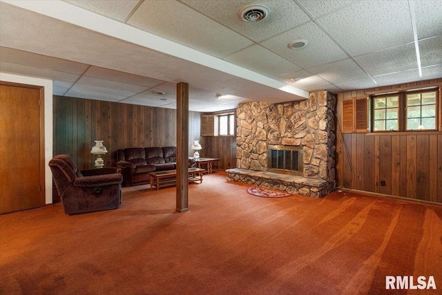 17223 N Cedar Rd, East Moline, IL 61244 - carpeted living area featuring a drop ceiling, wooden walls, and a stone fireplace