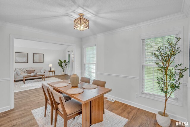 1039 Bluff Ln, Le Claire, IA 52753 - dining area featuring light wood finished floors and crown molding