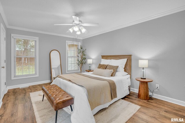 1039 Bluff Ln, Le Claire, IA 52753 - bedroom with wood finished floors, ornamental molding, and a ceiling fan