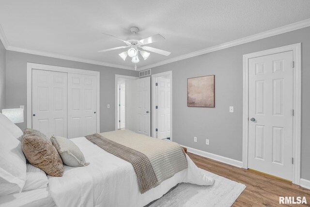 1039 Bluff Ln, Le Claire, IA 52753 - bedroom featuring wood finished floors, ornamental molding, a closet, and ceiling fan