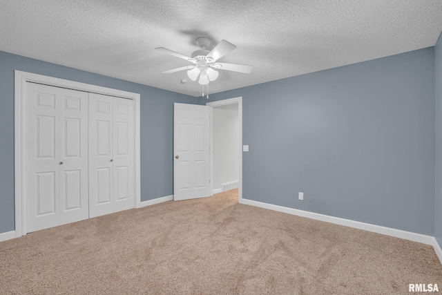 1039 Bluff Ln, Le Claire, IA 52753 - unfurnished bedroom featuring carpet floors, a textured ceiling, a closet, and a ceiling fan