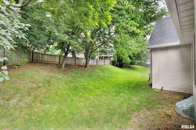 1039 Bluff Ln, Le Claire, IA 52753 - back of house featuring a shingled roof and a yard