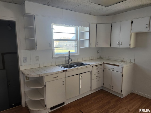 625 W Prospect St, Kewanee, IL 61443 - kitchen featuring open shelves, white cabinets, dark wood-style floors, tile countertops, and a paneled ceiling