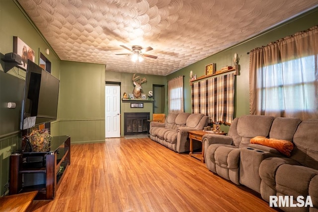 17000 Log Cabin Rd, Marion, IL 62959 - living area featuring ceiling fan, wood finished floors, a fireplace, wainscoting, and a textured ceiling