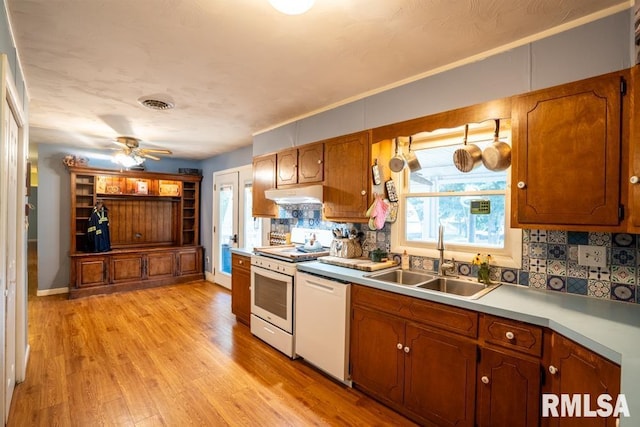17000 Log Cabin Rd, Marion, IL 62959 - kitchen featuring white appliances, under cabinet range hood, backsplash, light wood finished floors, and brown cabinets