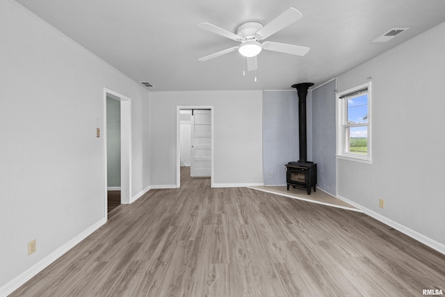 1671 US Highway 67, Preemption, IL 61276 - unfurnished room featuring wood finished floors, ceiling fan, and a wood stove