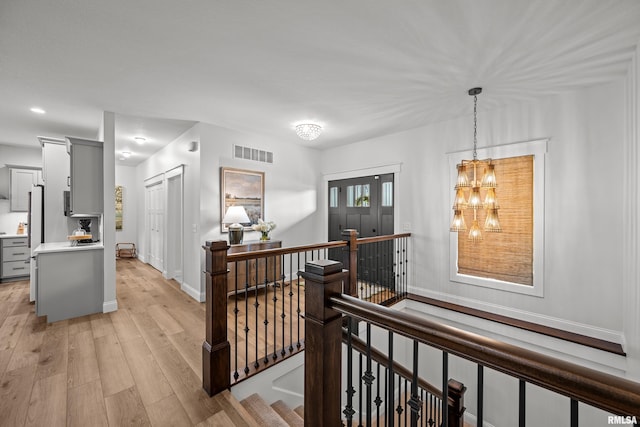 5835 Pigeon Creek Rd, Bettendorf, IA 52722 - hallway featuring an upstairs landing, light wood finished floors, a chandelier, and recessed lighting