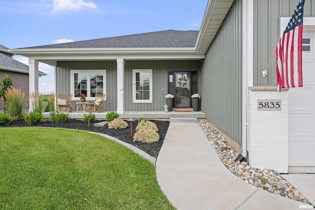 5835 Pigeon Creek Rd, Bettendorf, IA 52722 - property entrance with covered porch, board and batten siding, a shingled roof, and a lawn