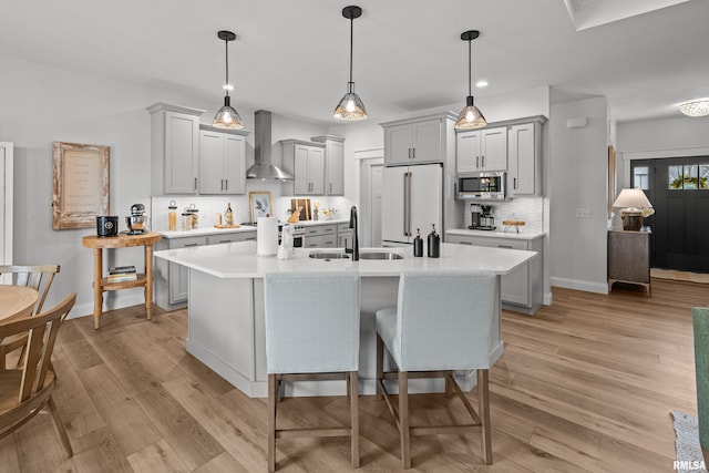 5835 Pigeon Creek Rd, Bettendorf, IA 52722 - kitchen featuring wall chimney exhaust hood, stainless steel microwave, high end fridge, light countertops, and backsplash