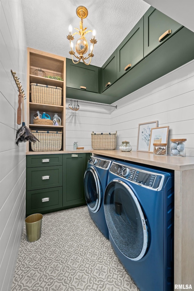 5835 Pigeon Creek Rd, Bettendorf, IA 52722 - laundry room with cabinet space, washing machine and clothes dryer, a chandelier, a textured ceiling, and wood walls