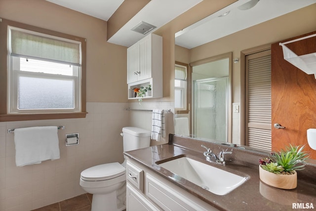 505 N 7th St, Eldridge, IA 52748 - bathroom with vanity, tile walls, tile patterned floors, a shower stall, and a wainscoted wall