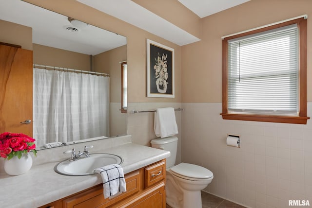 505 N 7th St, Eldridge, IA 52748 - bathroom featuring tile walls, vanity, tile patterned floors, wainscoting, and a shower with curtain